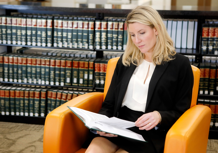 Woman sitting in library reading a book